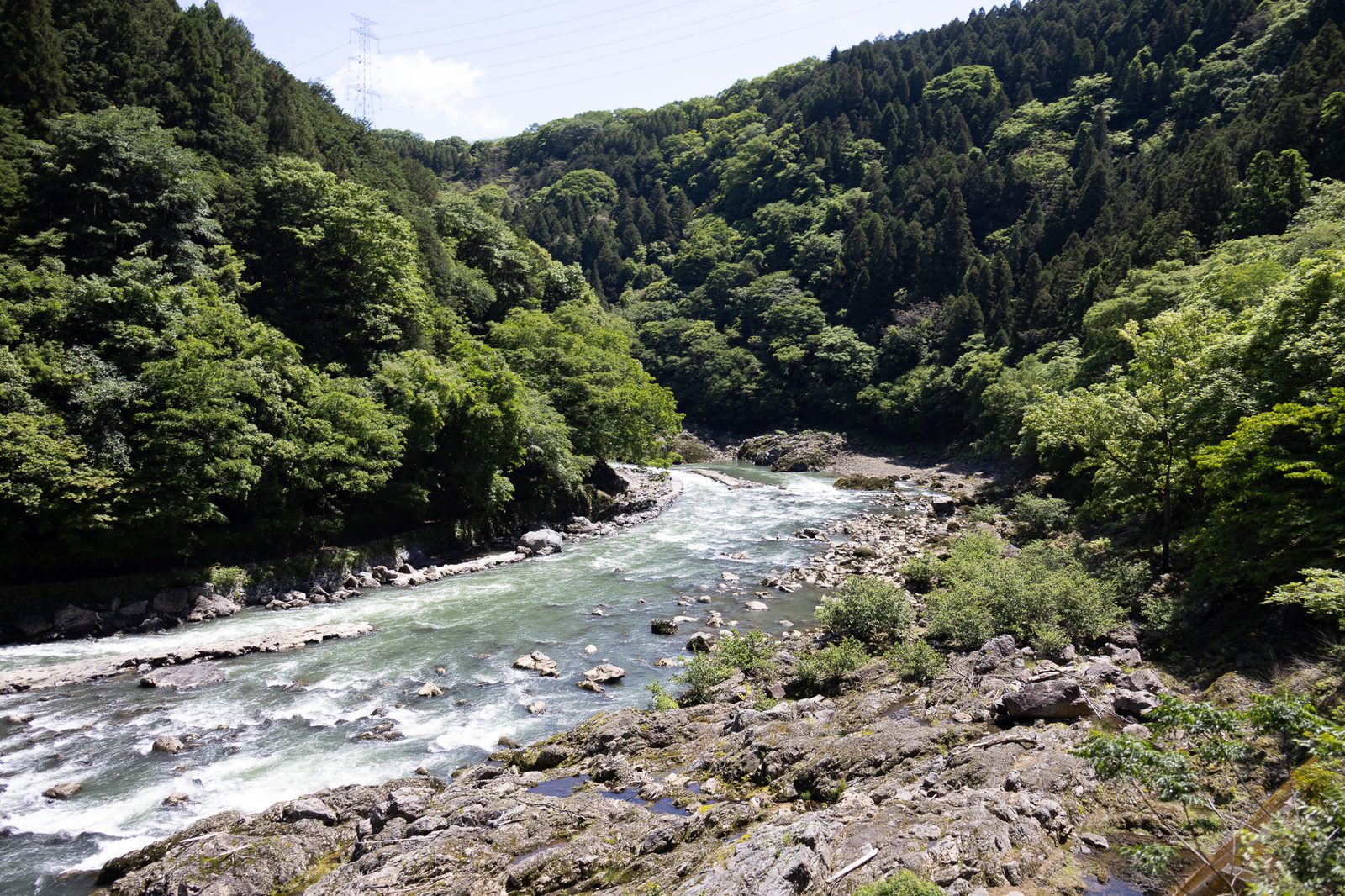 The Hozu River winding through the forested Hozukyo gorge seen from the Sagano Railway